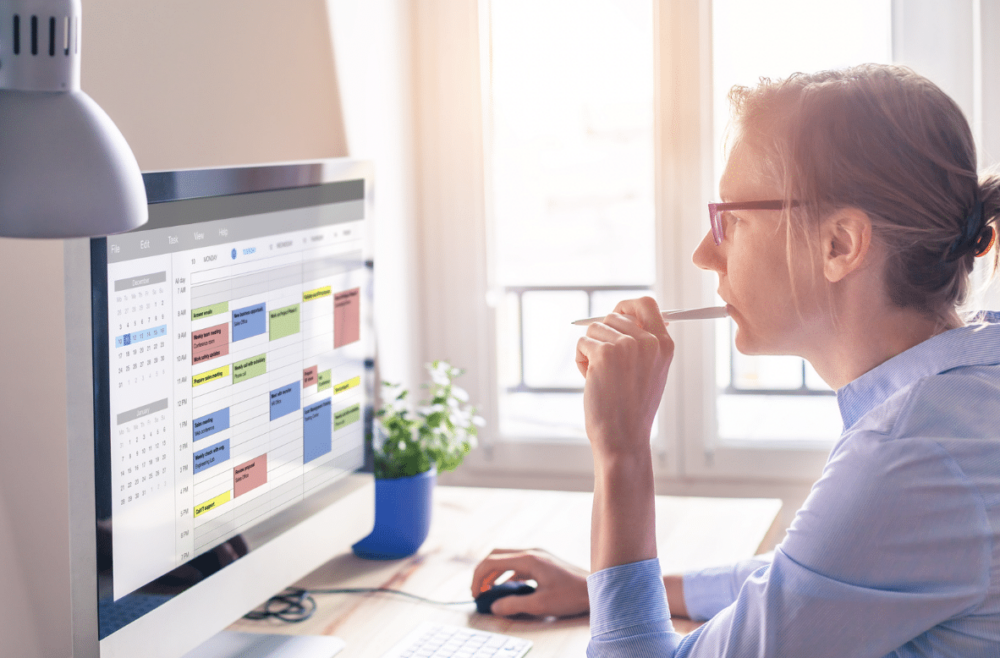 time management: woman looking at schedule on computer