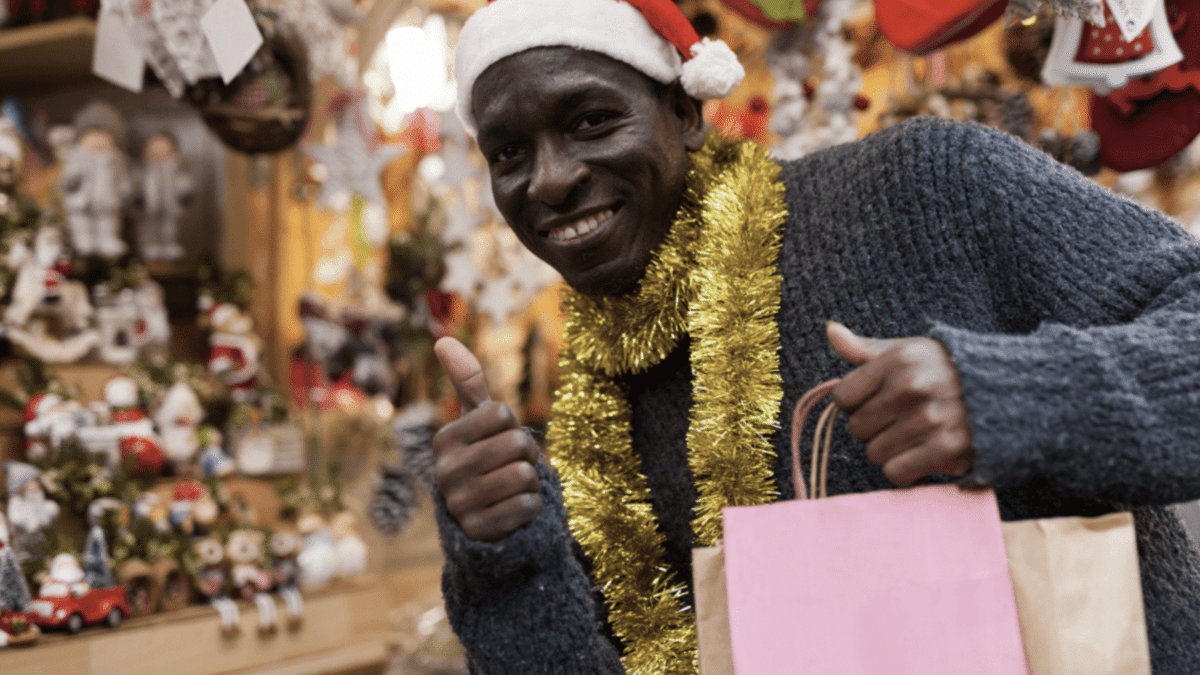 happy holiday customer. black man dressed in christmas garb giving thumbs up