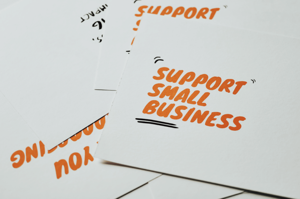 support small business written in orange on post cards