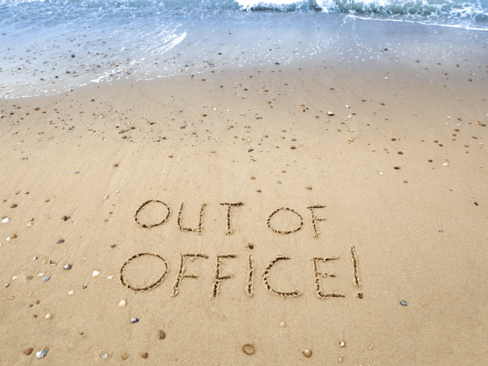 out-of-office written on the beach