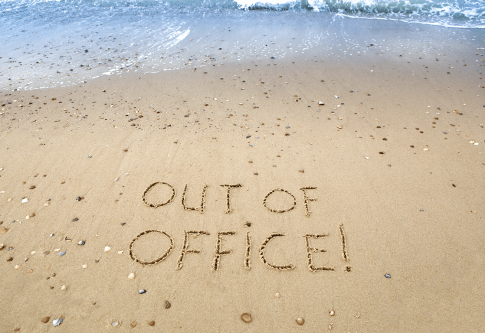 out-of-office written on the beach