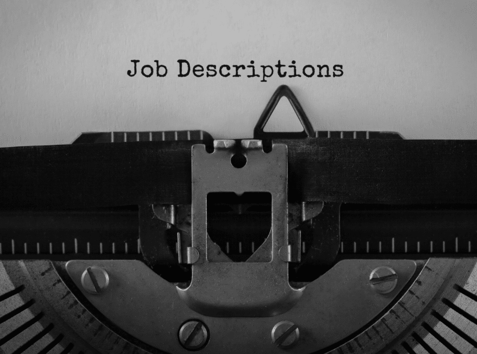 the phrase job descriptions typed out on paper using a typewriter