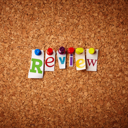 review in magazine cutouts pinned to cork board