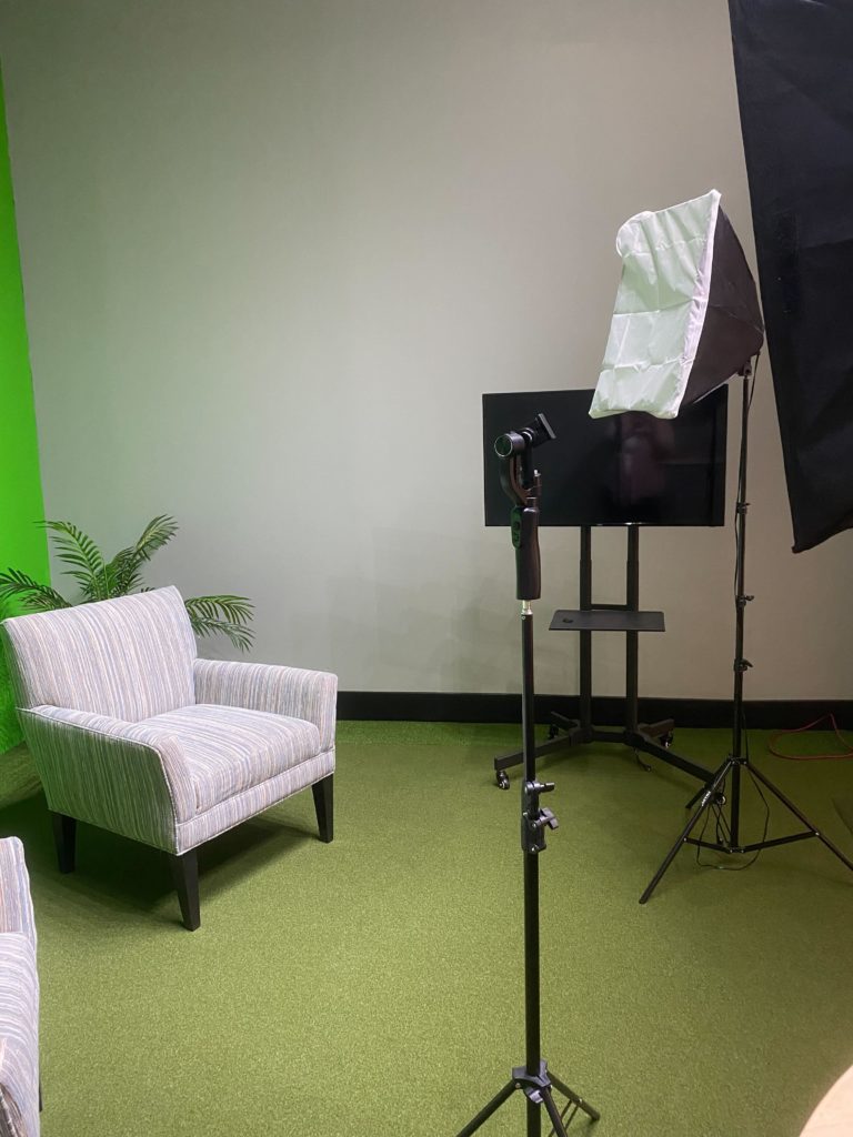 production room with seating, lighting, green screen and tv