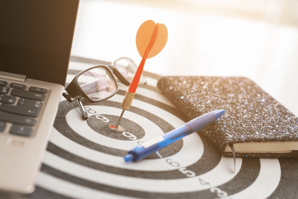 Office desk with a dart going through a target.