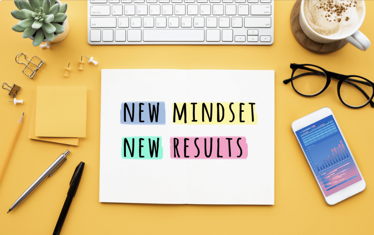 Yellow workspace desktop with positive mindset quote on paper.