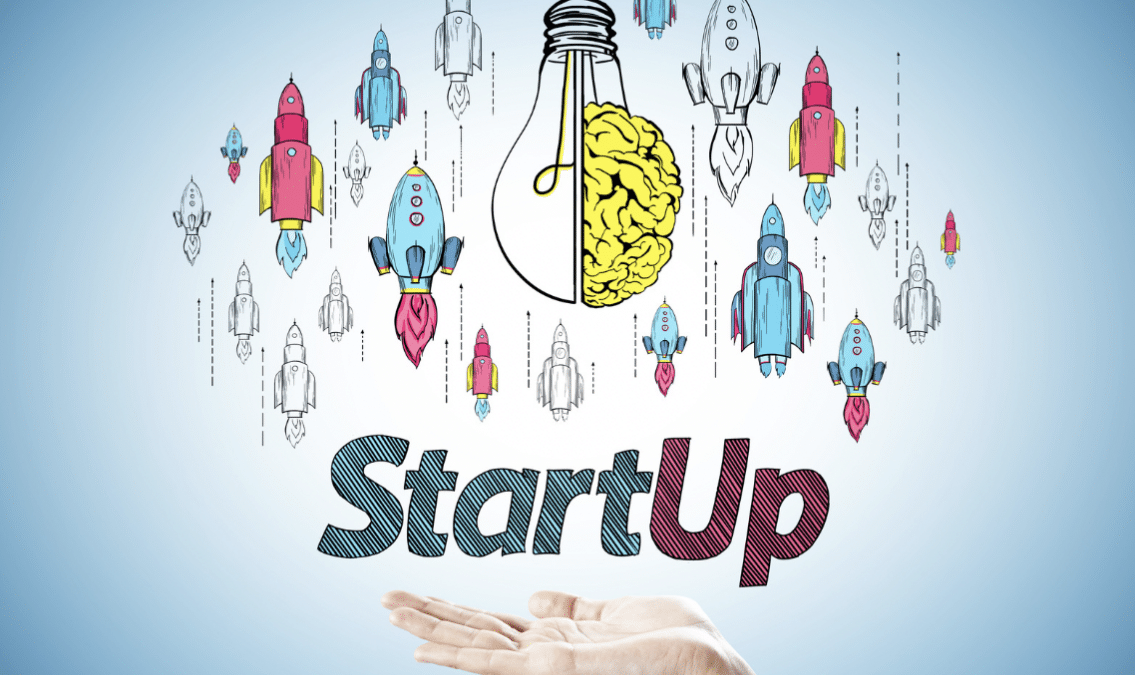 A hand holding underneath the words "Startup," surrounded by rocket ships and a lightbulb with a brain on one side of it.