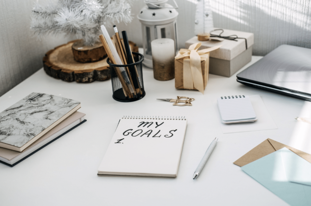 "My Goals" written on a tablet sitting on a desk surrounded by winter decor and office supplies ‣ NuvoDesk Coworking "My Goals" written on a tablet sitting on a desk surrounded by winter decor and office supplies