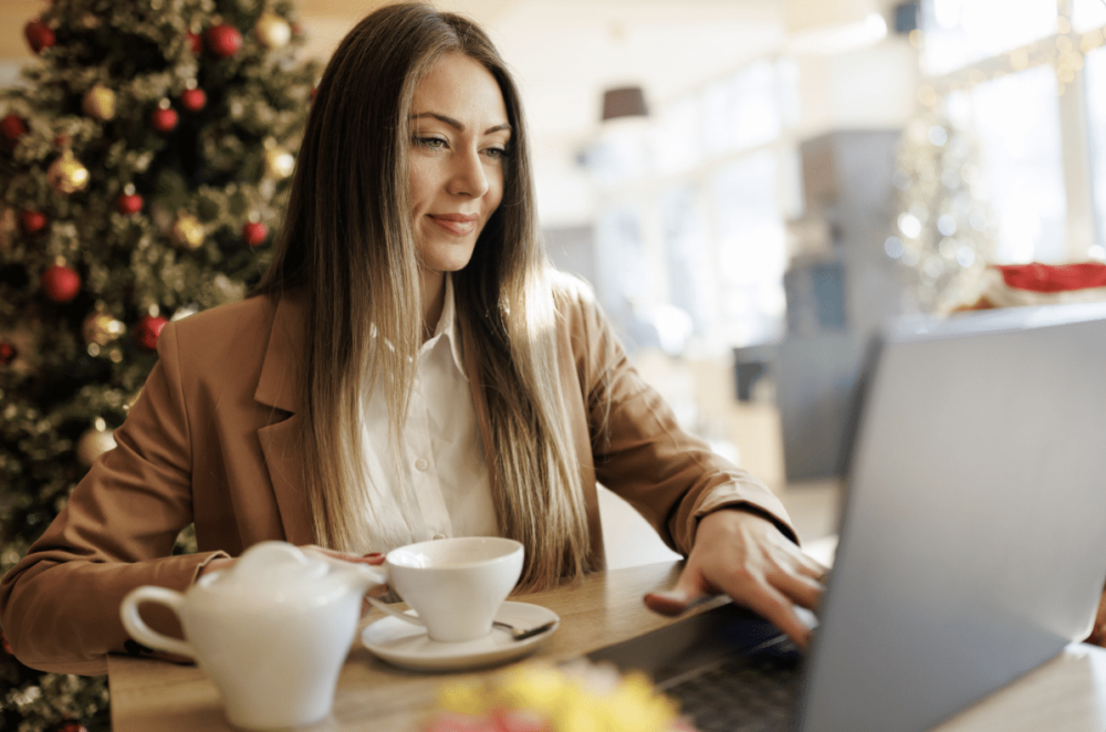 work-life balance during the holidays: lady working at laptop in front of Christmas tree ‣ NuvoDesk Coworking work-life balance during the holidays: lady working at laptop in front of Christmas tree