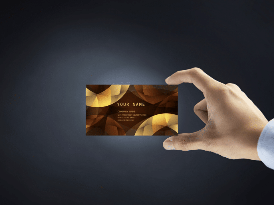 Business Card Design Tips That Will Make You Stand Out: man hand holding business card over black background