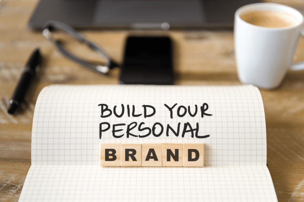 close up of notebook on vintage desk that reads build your personal brand