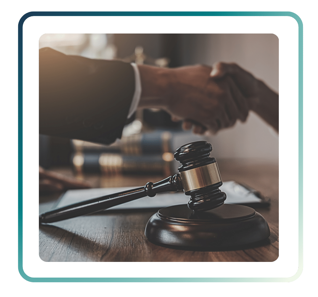 119 ‣ NuvoDesk Coworking Close up of handshake in a legal office with a judge’s gavel on the desk symbolizing agreement and partnership