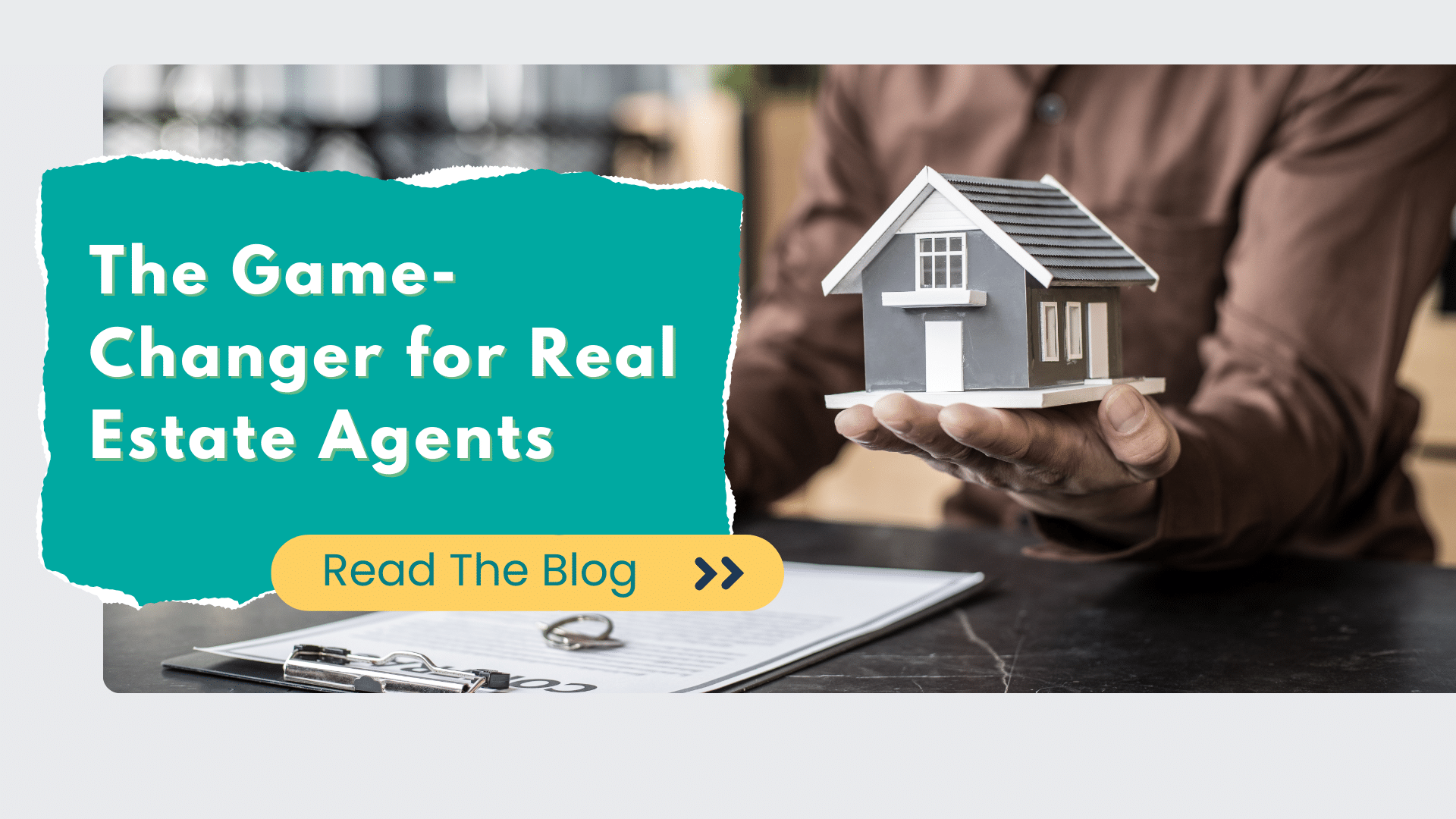 romotional graphic showing hands holding a small gray model house over a contract with a headline reading “The Game-Changer for Real Estate Agents” and a button that says “Read The Blog.”