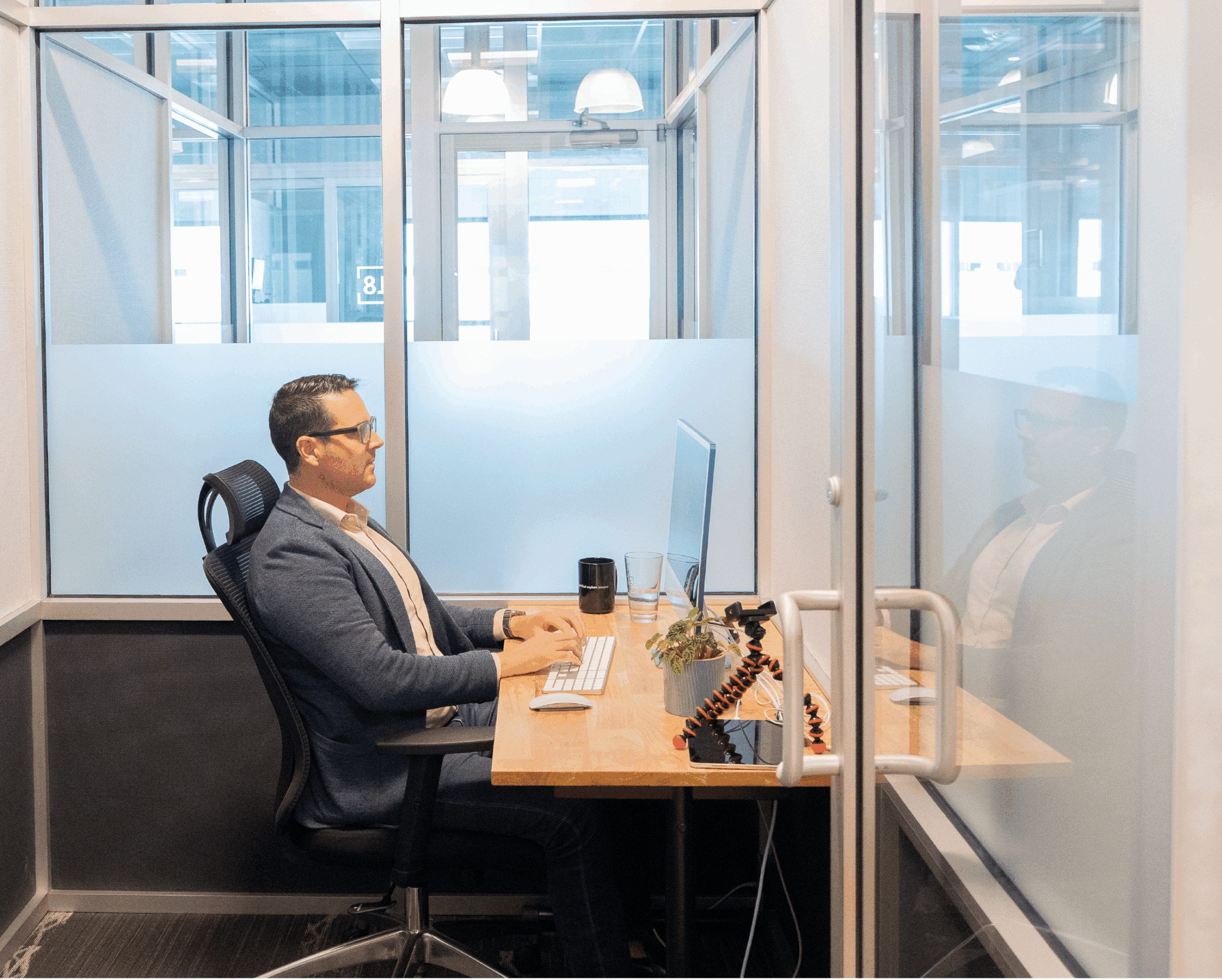 Professional Working in NuvoDesk Private Office ‣ NuvoDesk Coworking Man working at computer inside NuvoDesk Coworking private office